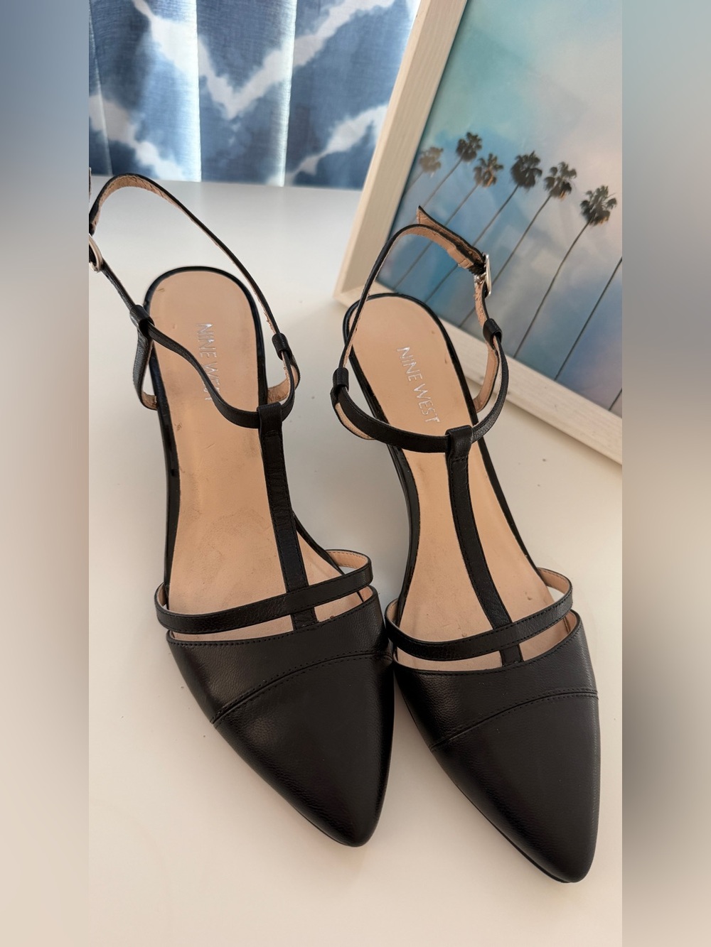 Nine West black T-strap pumps with a pointed toe and an adjustable ankle strap
